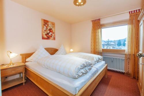 a bedroom with a large bed and a window at Ferienwohnung Brack in Reit im Winkl