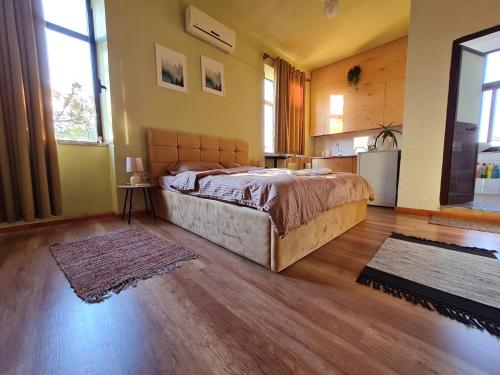 een slaapkamer met een groot bed en een keuken bij Ex-Block District charming studio apartment with treeish sorrounding view! in Tirana