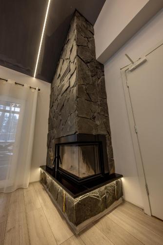 a fireplace in a room with a stone wall at Valsid puhkemaja in Alajõe