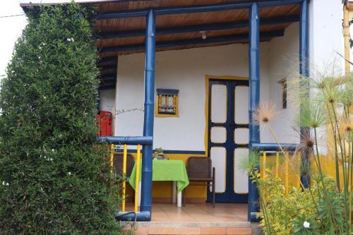 a house with a green table and a blue door at Chalet en Granja Campo Hermoso in Cogua