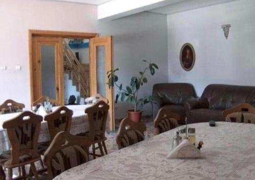 ein Wohnzimmer mit einem Tisch, Stühlen und einem Sofa in der Unterkunft Pensiunea Ursulet in Alexandru cel Bun