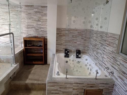 a large bathroom with a tub and a shower at HOTEL ZUHE in Paipa