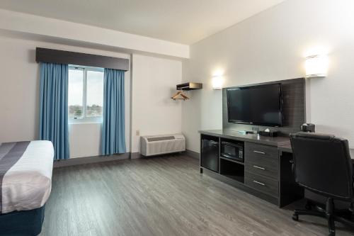 a hotel room with a bed and a flat screen tv at Comfort Hotel in Niagara Falls