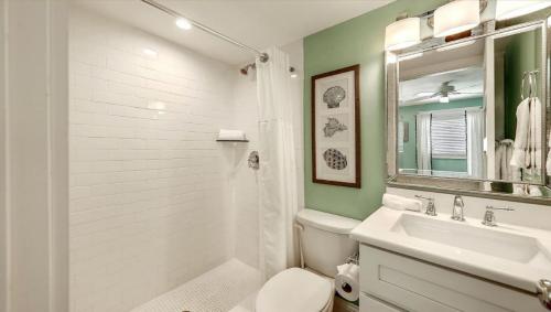 a bathroom with a sink and a toilet and a mirror at Canal Lower-Gorgeous 3 bed 3 bath near SK Village in Siesta Key