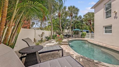 a swimming pool with a table and a chair next to a house at Canal Lower-Gorgeous 3 bed 3 bath near SK Village in Siesta Key