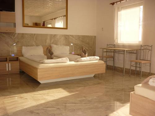 a living room with a couch and a mirror at R1 Rolléder Apartman-ház in Siklós