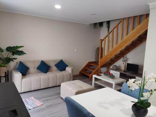 a living room with a couch and a staircase at Casa de Santo António in Aldeia de Santa Margarida