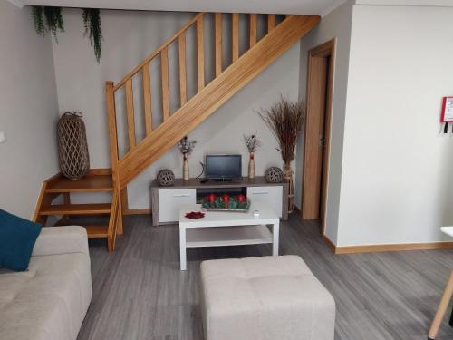 a living room with a staircase and a couch at Casa de Santo António in Aldeia de Santa Margarida