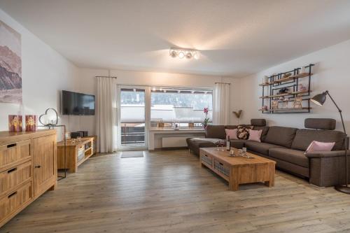 a living room with a couch and a coffee table at Ferienwohnungen Alpentraum - Alpentraum in Obermaiselstein