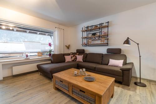 a living room with a couch and a coffee table at Ferienwohnungen Alpentraum - Alpentraum in Obermaiselstein