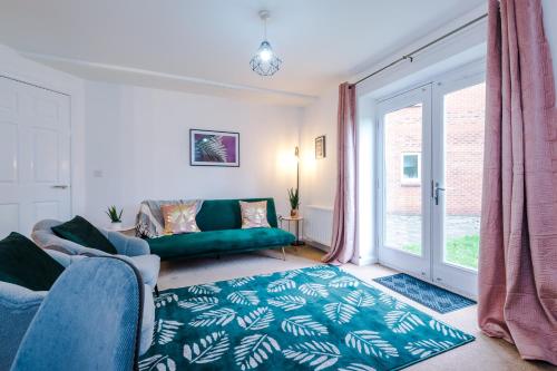 a living room with a green couch and a window at Goldsmith Serviced Apartment Coventry in Coventry