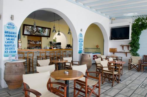 un ristorante con tavoli e sedie e un bar di Camping Koula a Paroikia