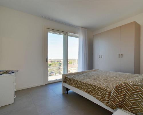 - une chambre avec un lit et une grande fenêtre dans l'établissement Residence Al Molo - Suite Porta del Mar Sea View - Agenzia Cocal, à Caorle