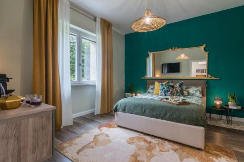 a bedroom with green walls and a bed with a mirror at Al Quadrato in Piobbico