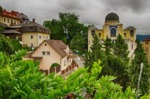 a yellow building with a dome on top of a town at Penzion Andy in Děčín