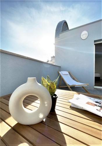 a white vase sitting on top of a wooden deck at Hey Studio - Free Parking and Smart TV in Aveiro