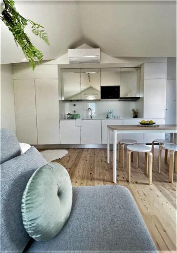 a living room with a couch and a dining room table at Hey Studio - Free Parking and Smart TV in Aveiro