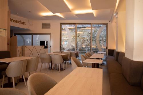 a restaurant with tables and chairs and a window at Hotel Porto Interface Trindade By Kavia in Porto