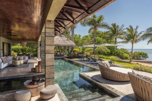 an infinity pool at a resort with chairs and the ocean at Four Seasons Resort Mauritius at Anahita in Beau Champ
