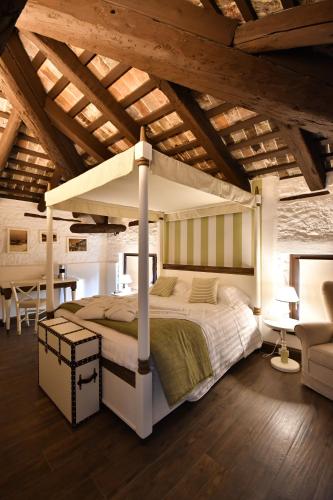 ウーディネにあるAl Palazzettoの木製の天井が特徴のベッドルーム1室(大型ベッド1台付)