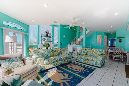een woonkamer met blauwe muren en banken bij Dolphin View by Meyer Vacation Rentals in Gulf Shores