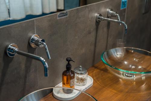 a bathroom counter with a sink and two faucets at Al Quadrato in Piobbico
