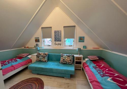Habitación en el ático con 2 camas y sofá en Strandperle 264 mit Sauna und Kamin, en Julianadorp
