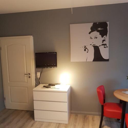 a room with a desk with a computer and a picture on the wall at Flensburg City - 24h in Flensburg
