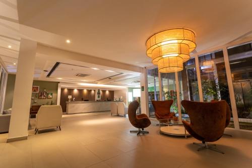 a lobby with chairs and a chandelier at Ecco Hotel Fortaleza in Fortaleza