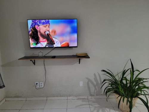 TV de pantalla plana en la pared de la sala de estar. en Sobrado 6 amplo e confortável em condomínio en Corumbá