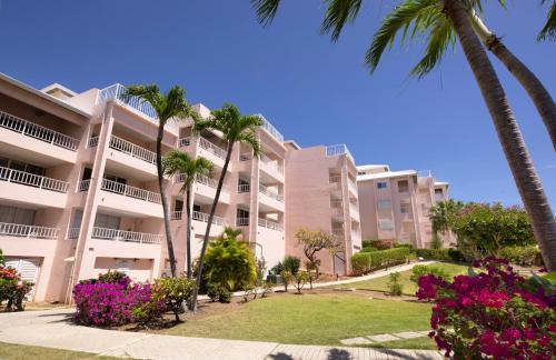 an apartment building with palm trees and flowers at Elysian Beach Resort in St Thomas