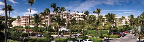 a large building with palm trees in a parking lot at Elysian Beach Resort in St Thomas