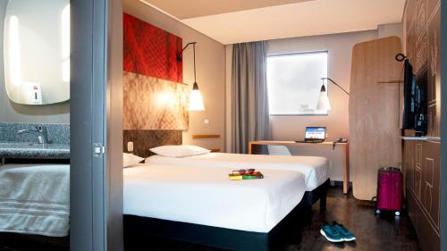 a hotel room with a white bed and a sink at ibis Barranquilla in Barranquilla