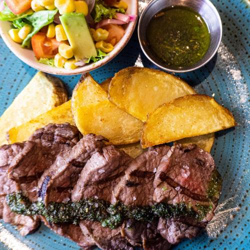 a plate of meat and a salad and a bowl of sauce at ibis Barranquilla in Barranquilla