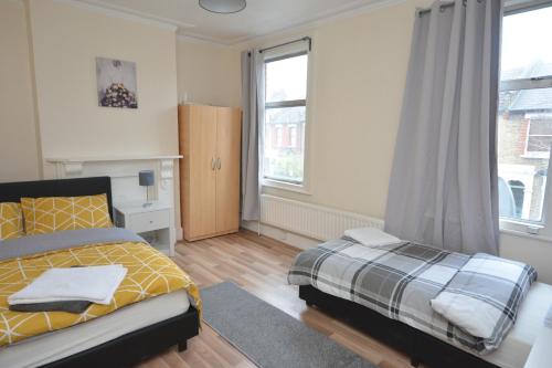 a bedroom with a bed and a large window at Cheerful 4 bedroom House in greater London in London