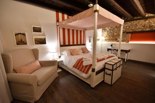 a bedroom with a canopy bed and a couch at Al Palazzetto in Udine