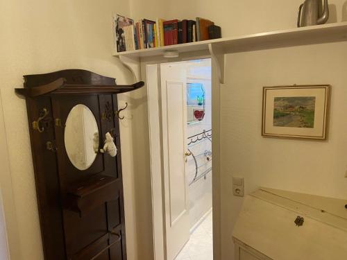 a bathroom with a mirror and a shelf with books at An der Marsch in Alkersum