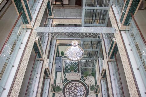 a glass hallway with a chandelier in a building at Garden Plaza Bukhara in Bukhara
