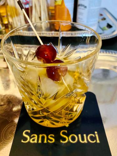 a glass bowl with a drink with a cherry in it at Sans Souci Bed and Breakfast Luxe Heated Pool and Restaurant in Luzillé