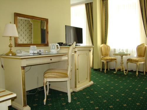 a hotel room with a desk with a television and a mirror at Hotel Saint Petersburg in Karlovy Vary