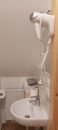 a bathroom with a white sink and a hairdryer at Grażynka in Zakopane