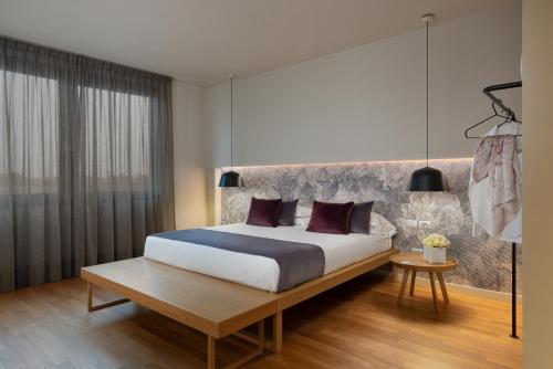 um quarto com uma cama king-size e uma mesa em Hotel Leopardi em Verona