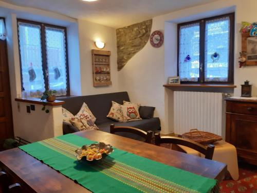 a living room with a table and a couch at Sauze d'Oulx ciabot la garitüla with garden - wifi- close to the chairlift in Sauze dʼOulx