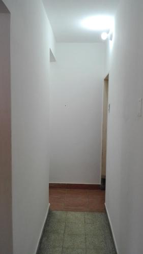 a hallway with a white wall and a light at DEPARTAMENTO CON COCHERA in La Rioja