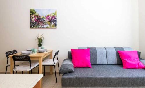 a living room with a couch and a table with pink pillows at Koletek st Apartment in Krakow