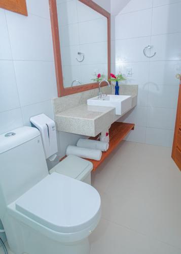a bathroom with a white toilet and a sink at Arraial Bangalô Praia Hotel in Arraial d'Ajuda