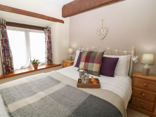 a bedroom with a bed with a tray on it at Beechcroft Cottage in South Molton