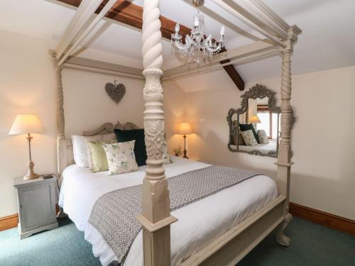 a bedroom with a four poster canopy bed at Hazel Barn in South Molton