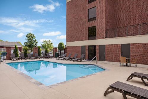 a swimming pool in front of a brick building at Comfort Suites Outlet Center in Asheville