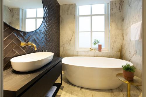 a bathroom with a large tub and a sink at Boutiquehotel Princenjagt in Middelburg